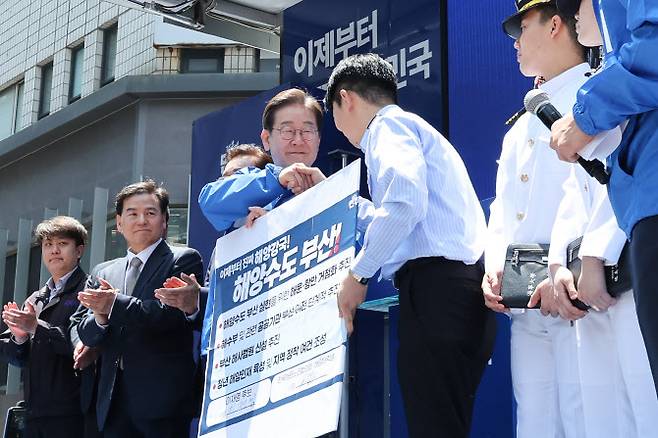 이재명 더불어민주당 대통령 후보가 민주당 험지로 꼽히는 부산·경남(PK) 지역 유세에 나선 14일 부산 부산진구 서면에서 권기흥 에이치라인해운해상직원노조 위원장과 해양수도 부산 협약서에 서명한 뒤 악수하고 있다.(사진=뉴스1)