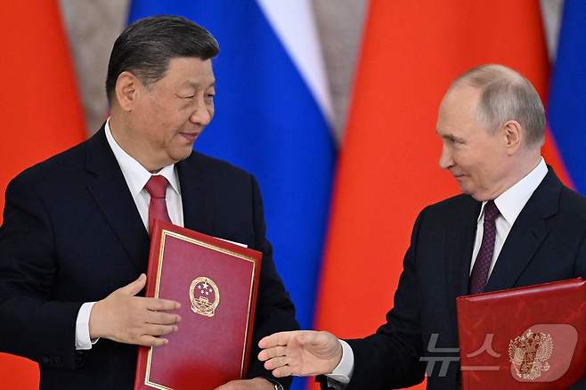 블라디미르 푸틴 러시아 대통령과 시진핑 중국 국가주석이 8일(현지시간) 모스크바 크렘린 궁에서 회담을 마친 뒤 협약서를 교환하고 있다. 2025.05.09 ⓒ AFP=뉴스1 ⓒ News1 우동명 기자
