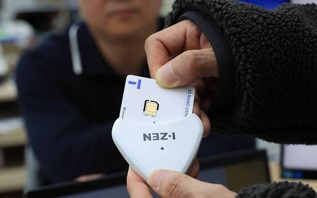 서울의 한 SKT 대리점에서 직원들이 ‘유심 재설정’을 시연하고 있다. 연합뉴스