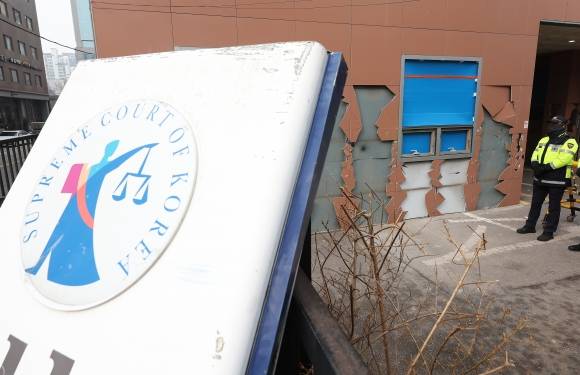 지난 1월 서울서부지방법원에서 철제 간판이 훼손돼 외벽에 기대어져 있다. 연합뉴스
