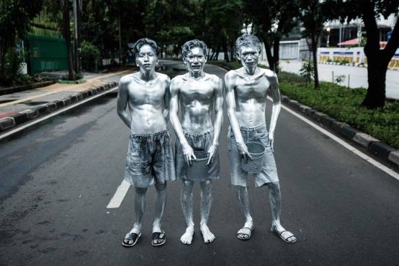 지난달 1일 인도네시아 자카르타의 길가에서 자세를 취하고 있는 ‘실버맨’ 아리 무난다르(가운데)와 그의 동생 케리스(오른쪽), 친구 리얀 아마드 파즈리얀사. AFP 연합뉴스