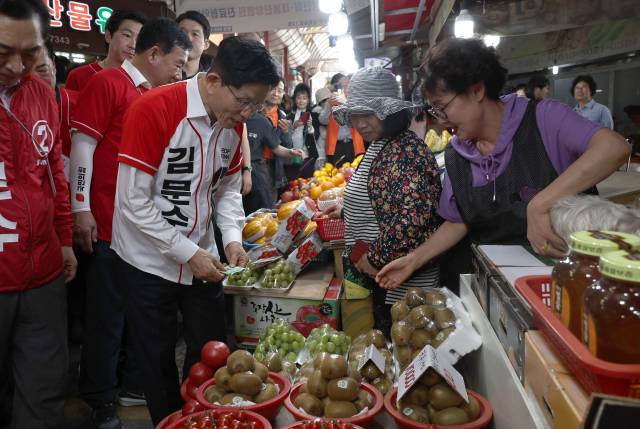김문수 국민의힘 대선거 후보가 13일 오후 울산 남구 신정시장을 찾아 과일을 구매하고 있다. 울산=성형주 기자