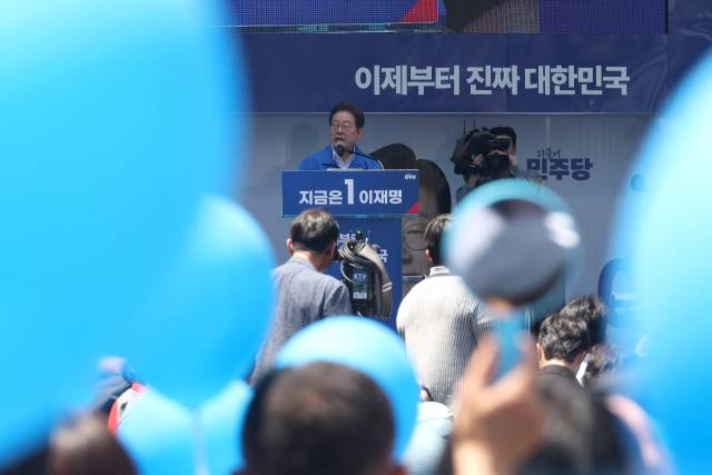 이재명 더불어민주당 대선 후보가 14일 부산 부산진구 서면거리에서 유권자들에게 지지를 호소하고 있는 가운데 지지자들이 파란풍선과 거울을 들고 있다. 부산=오승현 기자 2025.05.14