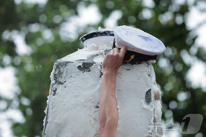 미국 해군사관학교에서 사관생도들이 14일(현지시간) 미국 메릴랜드 주 아나폴리스 미 해군 사관학교에서 '딕시 컵'을 떨어뜨리기 위해 인간 피라미드를 만들어 헌던 기념물 꼭대기에 오르고 있다. ⓒ AFP=뉴스1