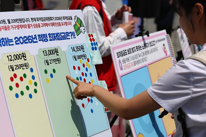 지난 14일 서울 종로구 광화문광장에서 전국서비스산업노동조합연맹 주최로 열린 ‘같이 살자! 최저임금! 오픈마이크\'에서 2026년 최저임금 적정 금액 설문이 이뤄지고 있다. 연합뉴스