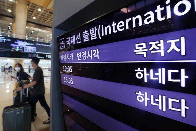 여행객들이 2022년 7월 25일 서울 강서구 김포공항 국제선 청사에 설치된 국제선 출발 정보가 나오는 전광판 옆을 지나가고 있다. 뉴스1