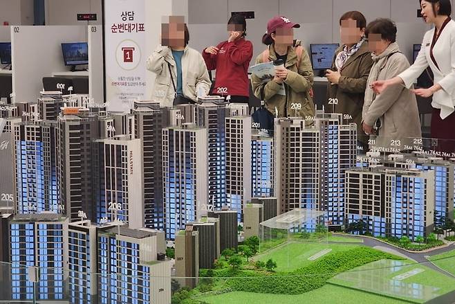 모델하우스 방문객들이 아파트 단지 모형을 둘러보고 있다. 사진=한경DB