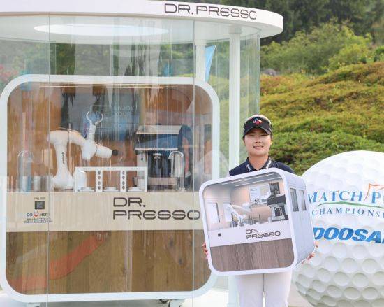 홍정민이 2022년 두산 매치플레이 우승 직후 부상으로 받은 무인카페 로봇 '닥터 프레소' 앞에서 미소를 짓고 있다. KLPGA