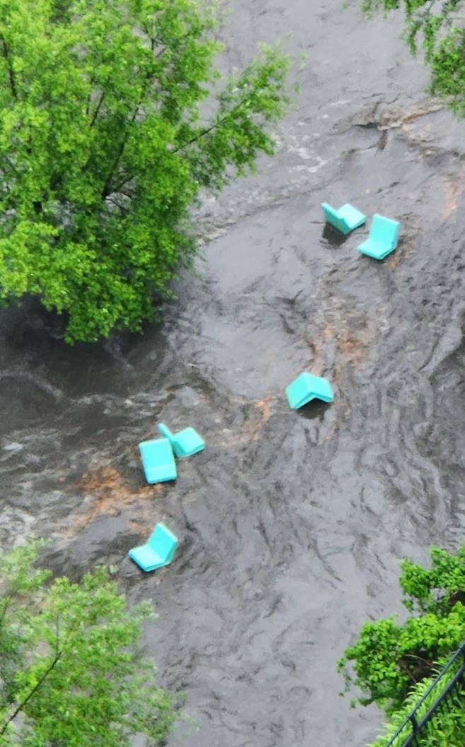 많은 비가 내린 16일 청계천 야외도서관 의자들이 불어난 물에 떠내려가고 있다./연합뉴스