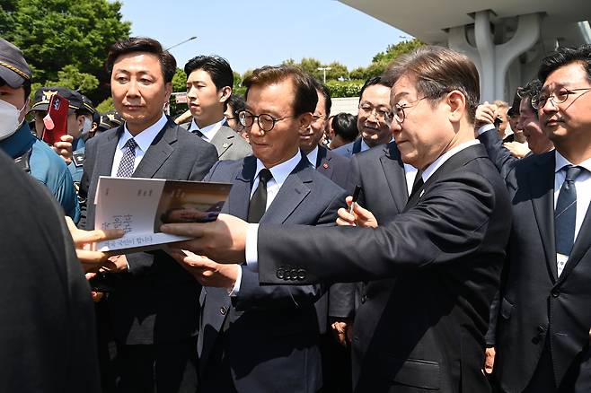 이재명더불어민주당 대선후보가 부산 남구 대연동 유엔평화공원에서 한 지지자가 건낸 자신의 책에 서명을 한 뒤 전달하고 있다. 김성룡 기자/