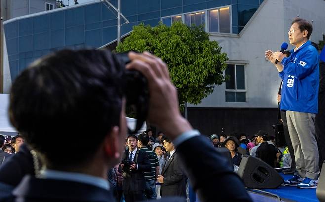 더불어민주당 이재명 대선후보가 15일 전남 목포시 평화광장 원형상가 앞에서 열린 유세에서 지지를 호소하는 연설을 하고 있다.
유세차 아래에서 경찰 경호 관계자가 테러 위협에 대응하기 위해 특수 쌍안경을 이용해 근처 건물을 계속 지켜보고 있다. 사진=연합뉴스