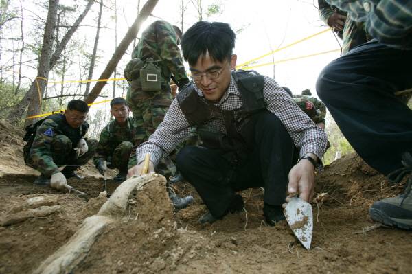 ▲ 2004년 4월16일 경북 군위군 의흥면 한 야산에서 '6·25 전쟁 전사자 유해발굴' 취재를 하면서 장병들과 함께 발굴 체험을 하고 있는 권혁철 기자. 사진=본인 제공