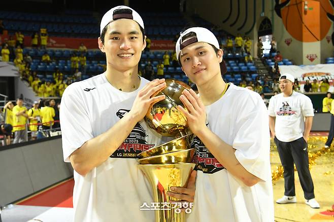 유기상(왼쪽)과 양준석이 지난 17일 서울 잠실학생체육관에서 열린 프로농구 챔피언결정전 7차전에서 첫 우승을 결정지은 뒤 트로피와 함께 기념 사진을 촬영하고 있다. KBL 제공