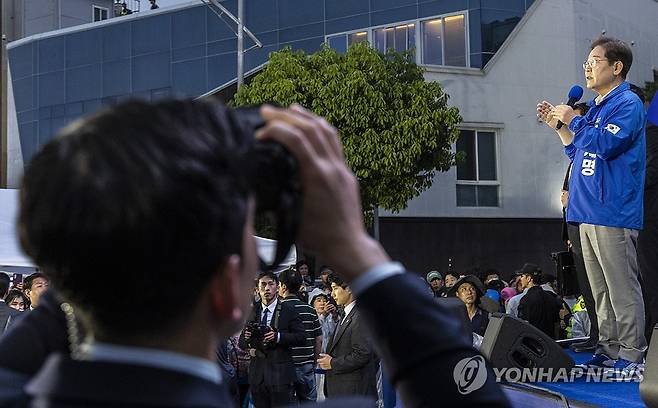이재명 후보는 연설, 경찰은 테러 대비 경호 (목포=연합뉴스) 황광모 기자 = 더불어민주당 이재명 대선후보가 15일 전남 목포시 평화광장 원형상가 앞에서 열린 유세에서 지지를 호소하는 연설을 하고 있다.
유세차 아래에서 경찰 경호 관계자가 테러 위협에 대응하기 위해 특수 쌍안경을 이용해 근처 건물을 계속 지켜보고 있다. 2025.5.15 hkmpooh@yna.co.kr
