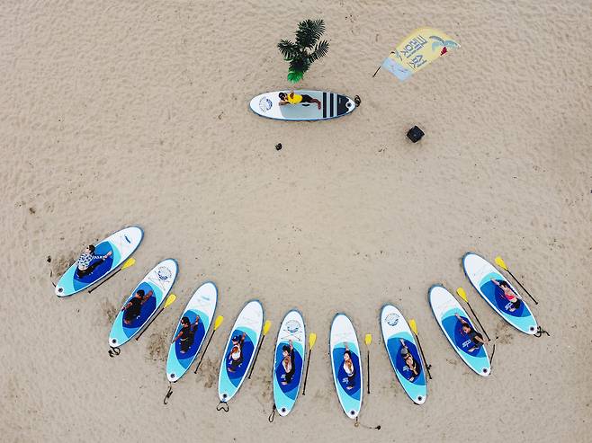 해변에서 진행하는 SUP 요가_크레이지 서퍼스 제공