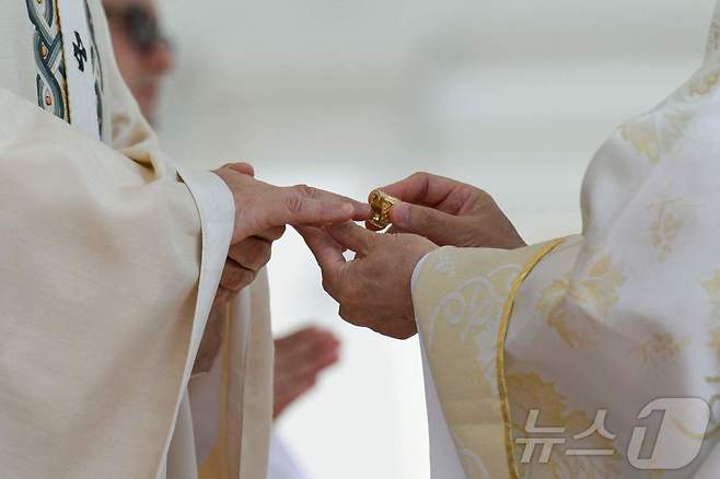 18일(현지시간) 바티칸 성 베드로 광장에서 열린 레오 14세 교황 즉위 미사에서 루이스 안토니오 고킴 타글레 추기경이 교황 레오 14세의 손가락에 어부의 반지를 끼워주고 있다.ⓒ AFP=뉴스1