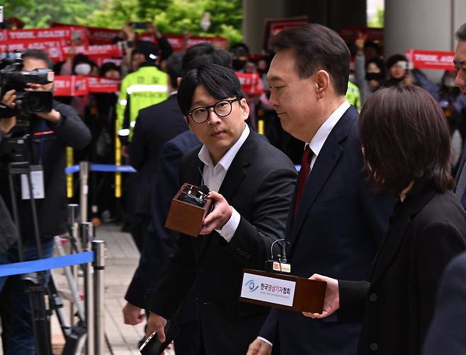 윤석열 전 대통령이 19일 오전 서울 서초구 중앙지방법원에서 열린 내란 우두머리 혐의, 직권남용 권리행사방해 혐의 사건 4차 공판에 출석, 취재진의 질문을 받으며 이동하고 있다. ⓒ사진공동취재단