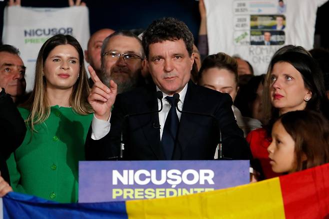 18일 루마니아 대선 결선 투표에서 승리한 친유럽연합 성향의 니쿠쇼르 단 대통령 당선인(가운데)이 같은 날 수도 부쿠레슈티에서 승리 연설을 하고 있다.
부쿠레슈티=AP 뉴시스