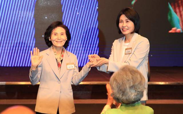 이재명 더불어민주당 대선 후보의 부인 김혜경(왼쪽) 여사와 김문수 국민의힘 대선 후보의 부인 설난영 여사가 12일 서울 중구 신라호텔에서 열린 중앙신도회 창립 70주년 기념식에서 손을 맞잡고 있다. 조계종 제공