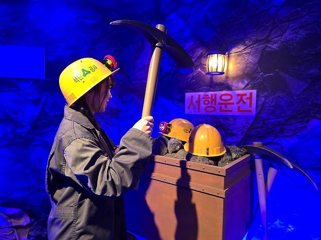 홍대 스타스퀘어빌딩에 마련된 강원랜드 ‘탄광 702동’팝업스토어에서 채탄 포즈를 취해보는 관광객