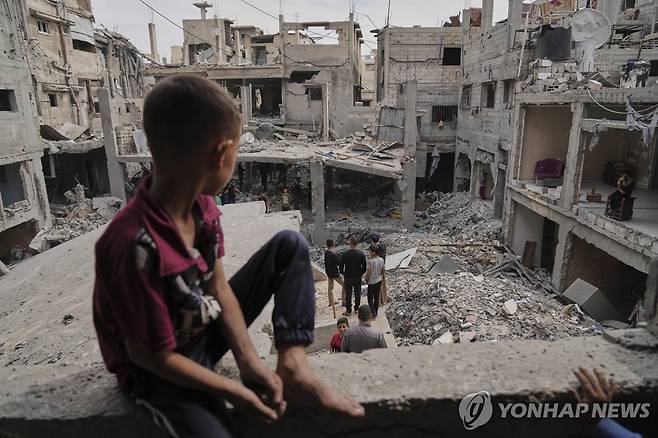 폐허 된 가자지구 (칸유니스 AP=연합뉴스) 지난 15일(현지시간) 가자지구 남부 칸유니스에서 건물 잔해 둘러보는 사람들. 2025.5.19 photo@yna.co.kr