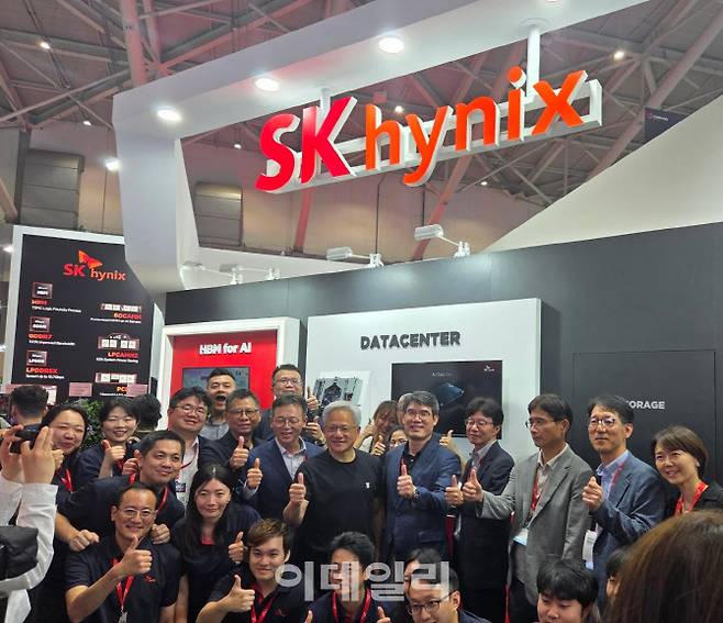 젠슨 황 엔비디아 CEO가 20일 대만에서 열린 ‘컴퓨텍스 2025’ SK하이닉스 전시관을 찾아 SK하이닉스 직원들과 사진을 찍고 있다. 사진=공동취재단