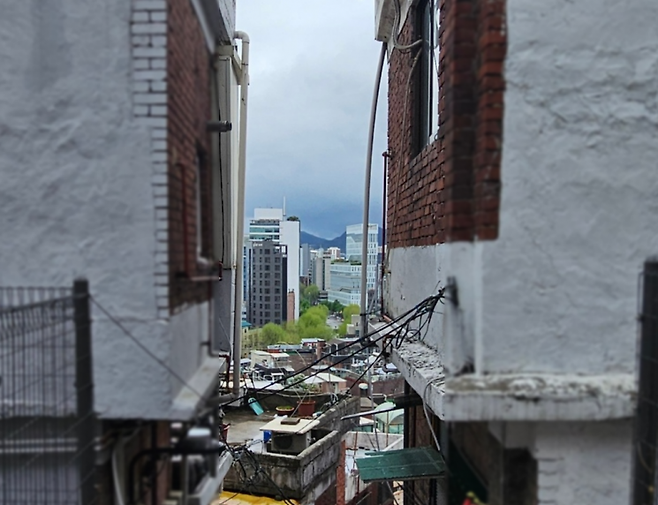 서울 종로구 충신1구역에 위치한 낡은 2층 주택 사이로 고층 빌딩이 보인다. 이지은 기자