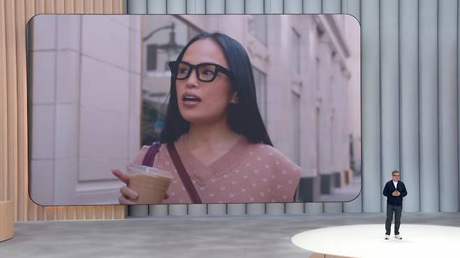 20일(현지시간) 미국 마운틴뷰 구글 본사에서 열린 개발자대회(I/O) 현장에서 한 여성이 구글의 새 스마트안경을 착용한 채 걸어가고 있는 영상이 나오고 있다./ 구글 유튜브 캡처