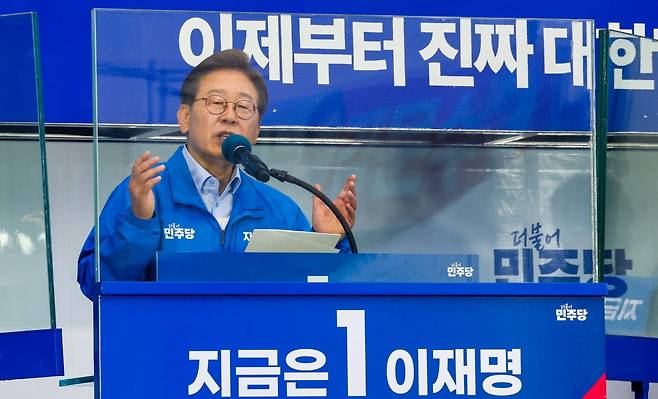 이재명 더불어민주당 대통령 후보가 사흘째 수도권 표심잡기에 나선 21일 오후 자신의 지역구인 인천 계양구 계양역을 찾아 유세하는 가운데 이 후보의 방탄 유리에 김문수 국민의힘 후보 현수막이 반사되어 비치고 있다, 뉴스1