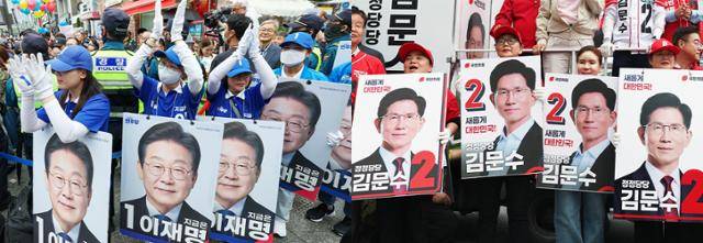 이재명 더불어민주당 대선 후보(왼쪽)와 김문수 국민의힘 대선 후보 선거운동원들이 20일 각각 경기 의정부시 로데오거리와 서울 강서구 남부골목시장 인근에서 선거운동을 펼치고 있다. 뉴스1