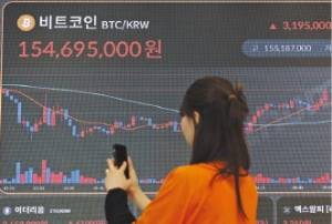 비트코인 가격이 22일 글로벌 시장에서 11만달러를 기록하며 신고가를 새로 썼다. 한 고객이 빗썸라운지 전광판의 비트코인 가격을 보고 있다. /최혁 기자