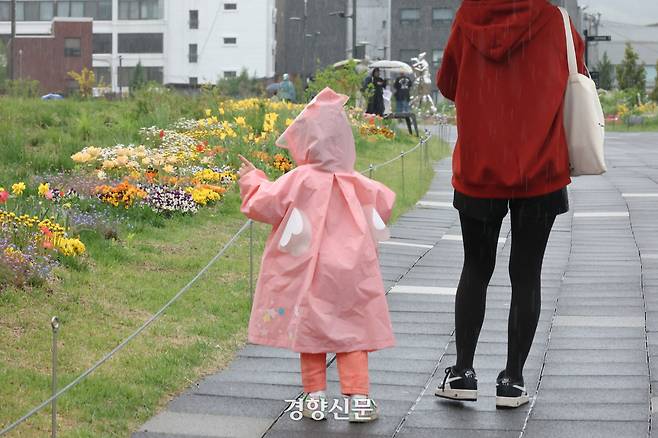 전국적으로 비가 내린 지난 1일 서울 종로구 열린송현 녹지광장을 찾은 시민이 꽃길 사이를 지나고 있다. 성동훈 기자