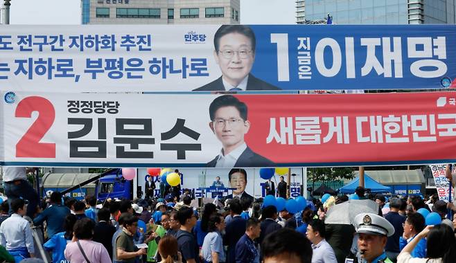 이재명 더불어민주당 대통령 후보와 김문수 국민의힘 후보의 지지율 격차가 한 자릿수로 좁혀졌다는 여론조사 결과가 발표되자 민주당은 '보수층 과표집' 가능성을 제기하며 경계심을 드러냈다. 사진은 이재명 더불어민주당 대선후보가 지난 21일 인천 부평구 부평역 북광장에서 열린 집중유세에서 지지호소를 하고 있는 가운데 이 후보와 김문수 국민의힘 대선 후보 현수막이 주변에 걸려있는 모습. /사진=뉴시스