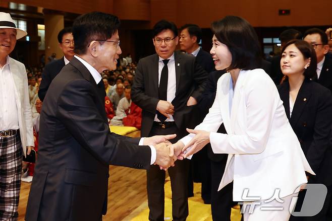 김문수 국민의힘 대통령 후보와 이재명 더불어민주당 대통령 후보 부인인 김혜경 여사가 24일 충북 단양군 구인사에서 열린 상월원각대조사 제51주기 열반대재에서 인사를 나누고 있다. 2025.5.24/뉴스1 ⓒ News1 김민지 기자