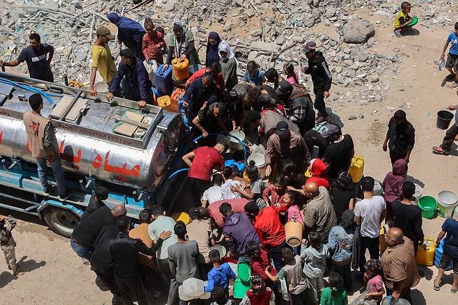 2025년 5월21일 팔레스타인 땅 가자지구 북부 가자시티에서 주민들이 급수차량 주변에 몰려 물을 배급받고 있다. AFP 연합뉴스