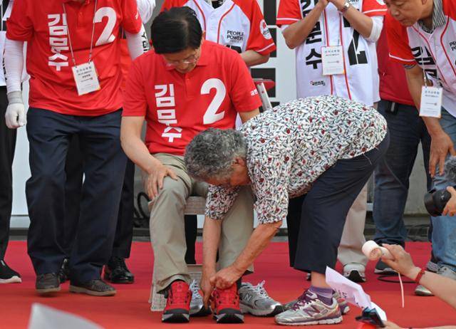 김문수 국민의힘 대선 후보가 22일 경기 부천시 부천역마루광장에서 열린 집중유세에서 의원 시절 인연이 있는 90세 할머니에게 빨간 운동화를 선물받고 있다. 하상윤 기자