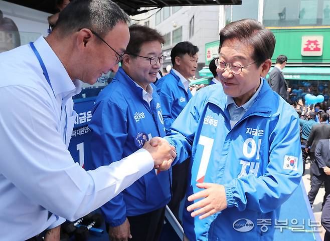 더불어민주당 이재명 대통령 후보가 26일 오후 수원시 영동시장 앞에서 열린 집중유세에 참석해 장재근 전 국가대표선수촌장과 인사하고 있다. 김경민기자
