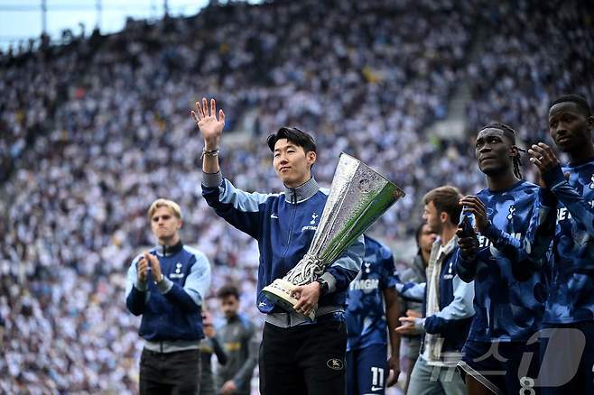 손흥민이 26일(한국시간) 열린 EPL 시즌 최종전이 끝난 뒤 유로파리그 우승 트로피를 들고 팬들에게 인사하고 있다. ⓒ AFP=뉴스1