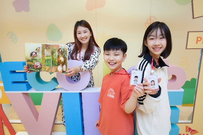 SK케미칼 구성원 가족이 명예 사원증과 봉사활동에 참여해 제작한 팝업북을 들고 기념 촬영하고 있다./사진=SK케미칼 제공