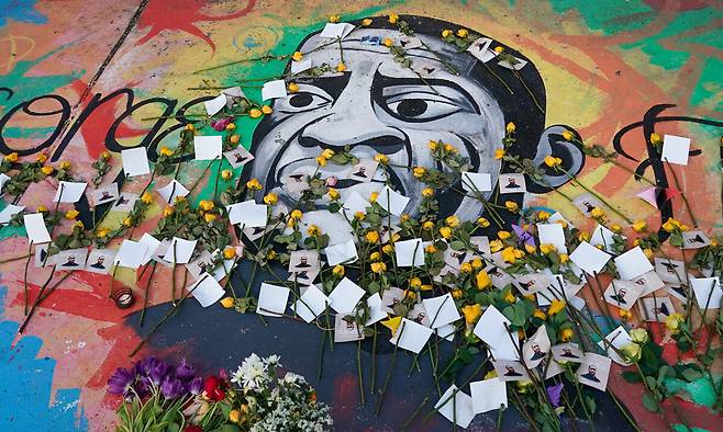 25일(현지시간) 미국 미네소타주 미니애폴리스에서 2020년 경찰의 과잉 진압으로 목숨을 잃은 흑인 조지 플로이드를 추모하는 꽃들이 그의 초상화 위에 놓여 있다. 미니애폴리스=EPA연합뉴스