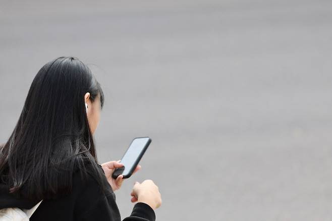서울 시내 한 중학교에서 하교하는 학생이 스마트폰을 사용하는 모습. (사진=연합뉴스)