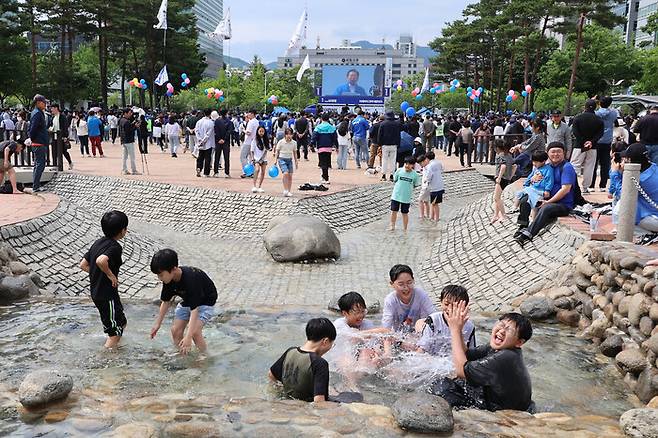 주말인 지난 24일 더불어민주당 이재명 대선 후보의 유세가 열린 경기 안양시 동안구 평촌중앙공원에서 어린이들이 물놀이를 즐기고 있다. 연합뉴스