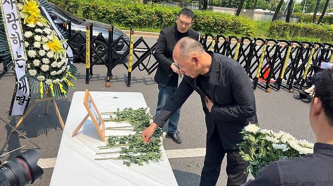 27일 오후 서울 영등포구 국회의사당역 4번 출구 앞에서 열린 ‘더블유진병원 격리·강박 사망사건 1주기 추모제’에 참석한 추모객이 헌화하고 있다. 최현수 기자