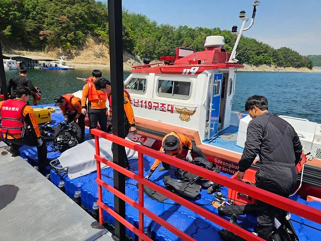 지난 19일 안동시 성곡동 안동댐 선착장 인근에서 경북소방본부 119구조대원들이 인양한 시신을 수습하고 있다. 시신은 신체 일부가 훼손됐지만 대체로 온전한 상태였다. /권광순 기자