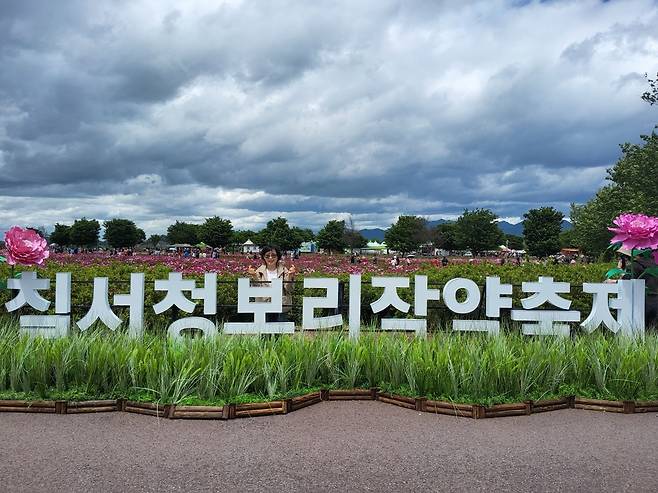 한 관광객이 ‘제3회 칠서생태공원 청보리·작약축제’ 포토존에서 기념촬영하고 있다.