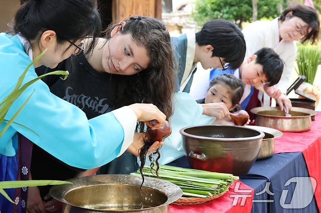 단오(음력 5월5일)를 이틀 앞둔 29일 서울 종로구 국립민속박물관에서 관광객들이 창포물에 머리 감기 체험을 하고 있다2025.5.29/뉴스1 ⓒ News1 신웅수 기자