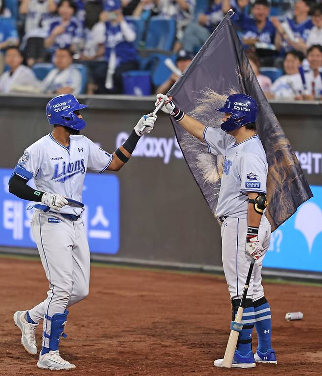 삼성 강민호(오른쪽)가 27일 대구삼성라이온즈파크에서 열린 2025 KBO리그 롯데전에서 7회말 홈런을 치고 돌아온 디아즈에게 사자 깃발을 전하고 있다. 사진 | 삼성 라이온즈