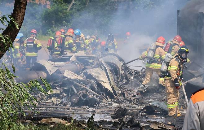 29일 오후 1시 50분쯤 경북 포항시 남구 동해면 신정리 한 야산에 해군 초계기가 추락한 가운데 소방관들이 화재 진압을 하고 있다. 연합뉴스