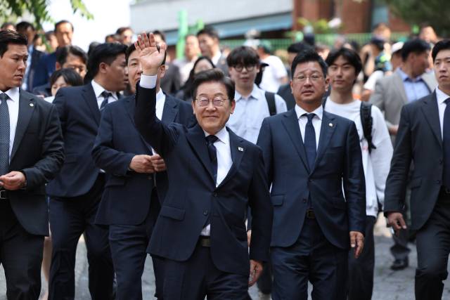 이재명 더불어민주당 대통령 후보가 제21대 대통령선거 사전투표 첫날인 29일 오전 서울 서대문구 구 신촌동주민센터에서 청년들과 투표를 마친 뒤 인사하고 있다. 공동취재