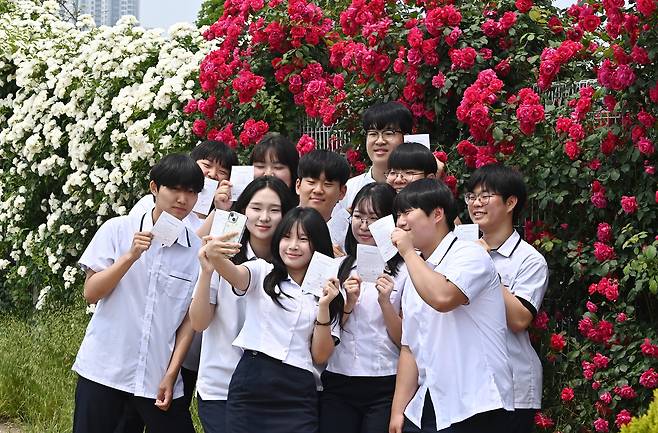 21대 대통령 선거 사전 투표가 시작된 29일 경기 수원 연무동 행정복지센터에 마련된 사전 투표소에서 고등학생들이 생애 첫 투표를 마친 뒤 선관위에서 발부한 투표 확인증을 들고 인증 샷을 찍고 있다. 선거일 기준 만 18세 이상(2007년 6월 4일생까지 포함) 국민은 주소지와 상관없이 전국 3568개 사전 투표소에서 29~30일 오전 6시부터 오후 6시까지 대선 사전 투표를 할 수 있다./뉴시스